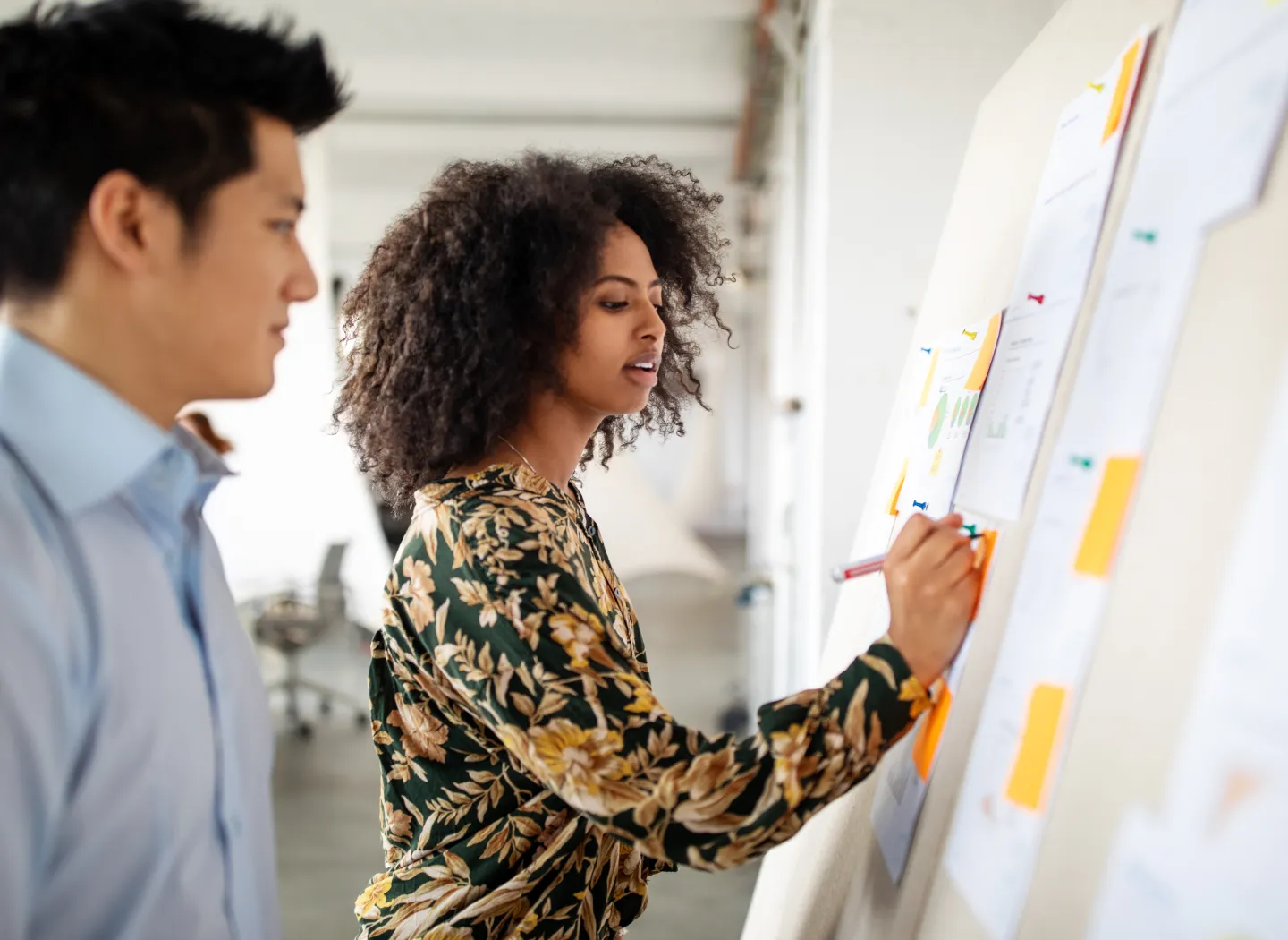 Professional woman in an office working with colleagues, representing collaboration and digital skills emphasized in a Certificate in Marketing program.