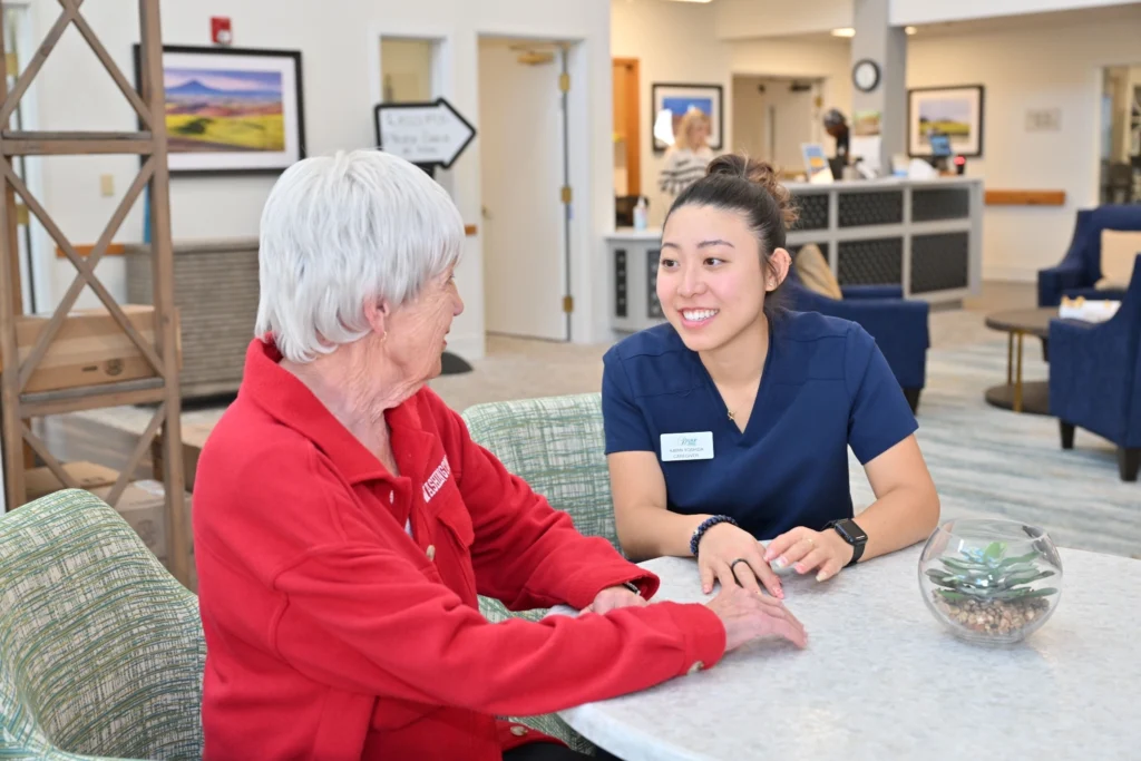A caregiver and a WSU representative seated at a table.
