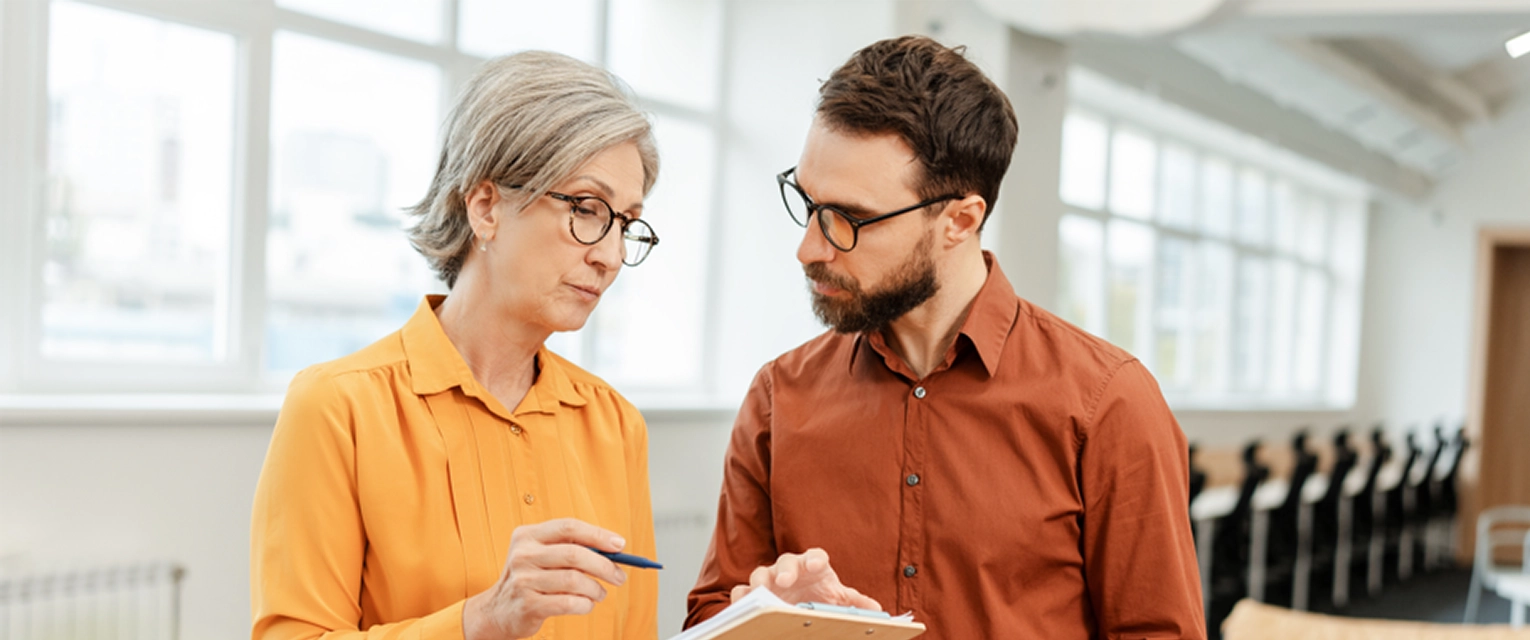 Two people discussing over a clipboard.